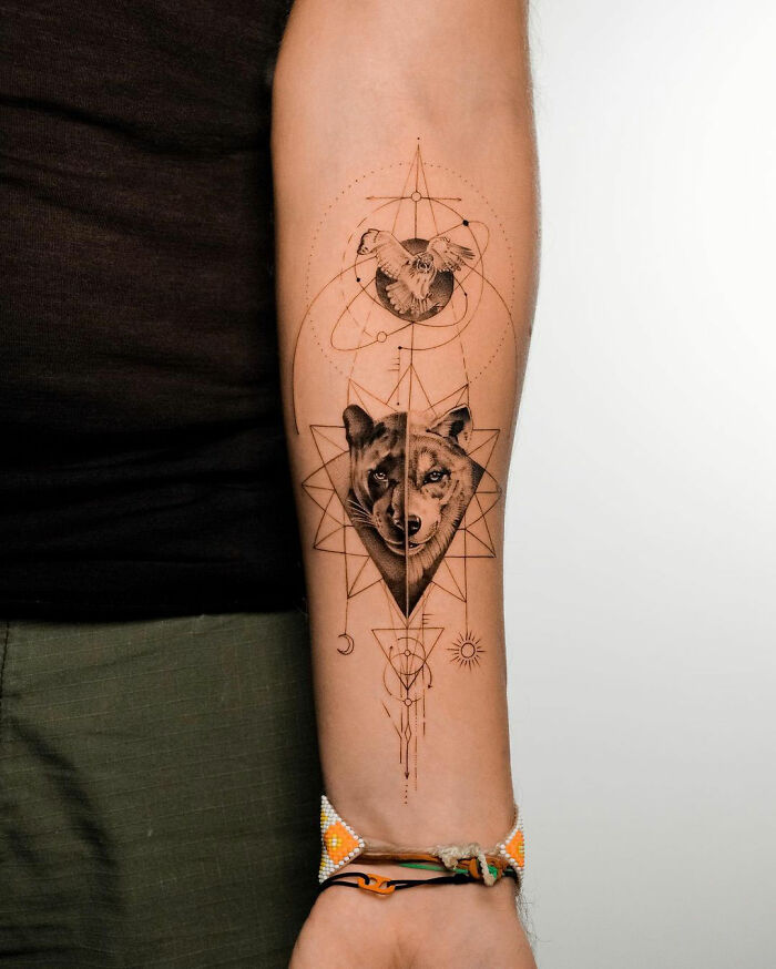 Wolf and eagle animal tattoo on forearm with geometric designs, showcasing a creative tattoo inspiration.