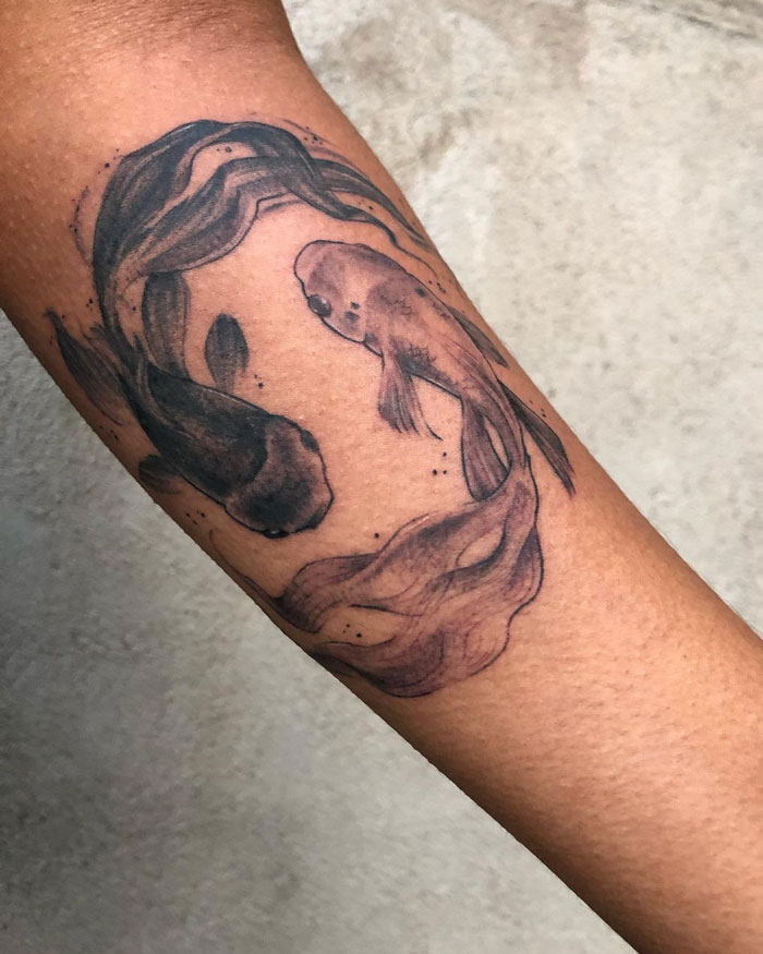 Minimalistic koi fish animal tattoo on forearm, showcasing realism and simplicity.