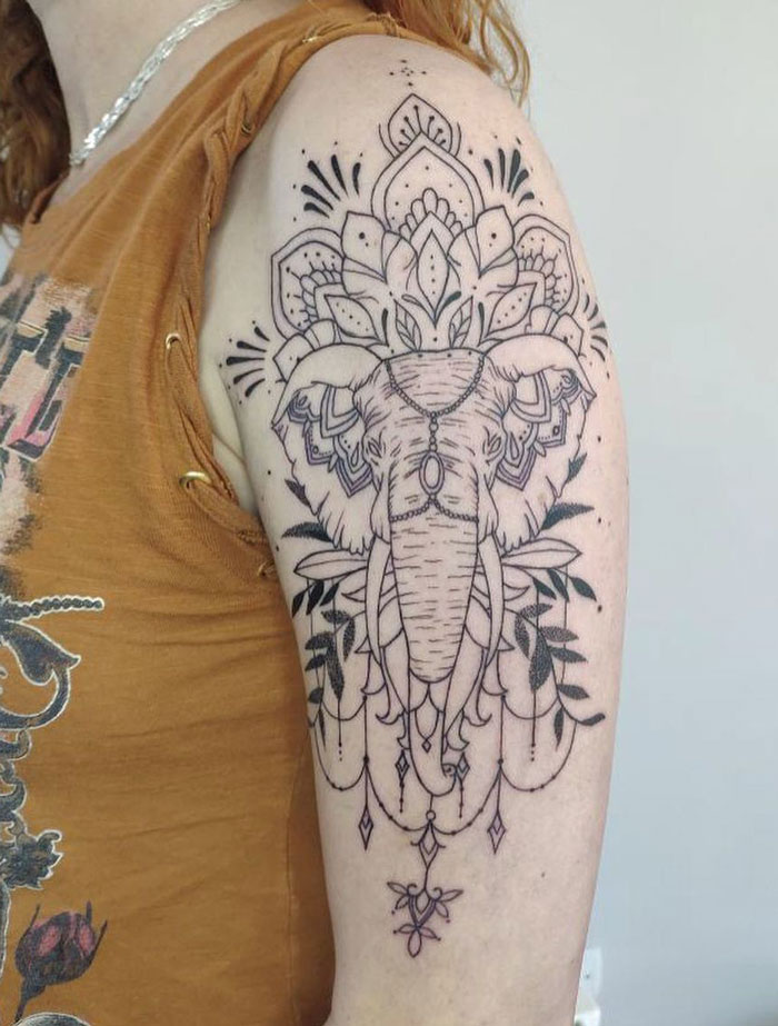 Linear elephant face tattoo on arm