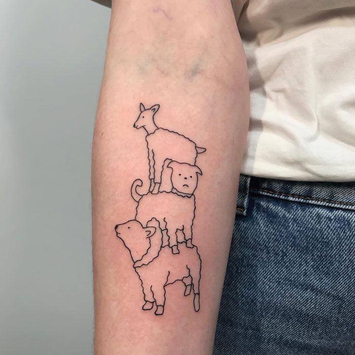 Animal tattoo line art on forearm featuring stacked sheep, pig, and goat, each outlined in black ink.