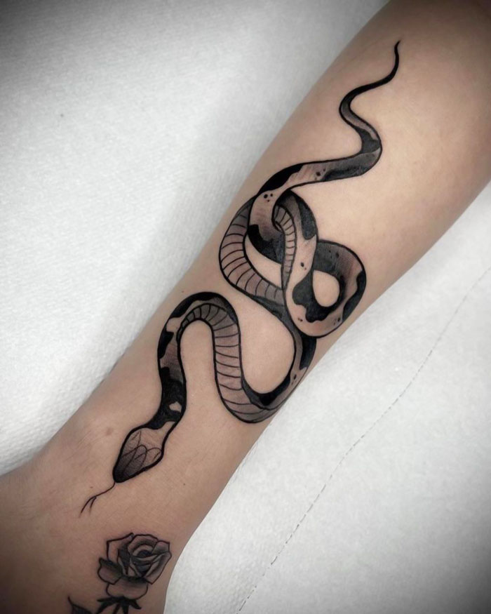 Black snake tattoo on arm
