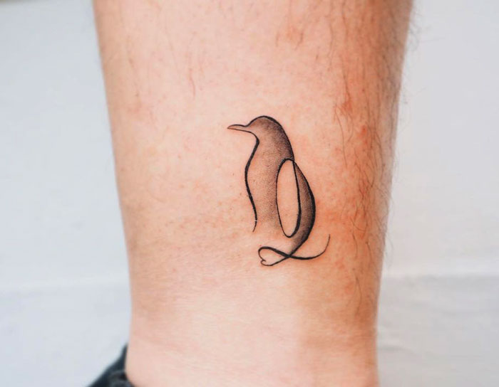 Penguin tattoo design on skin showcasing simplicity and realism in animal art.