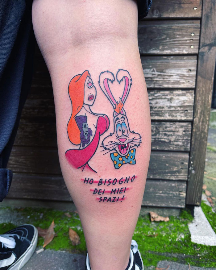 Colorful calf tattoo featuring animated characters with Italian text.