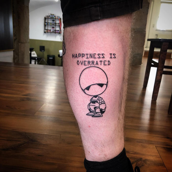 "Happiness Is Overrated" calf tattoo