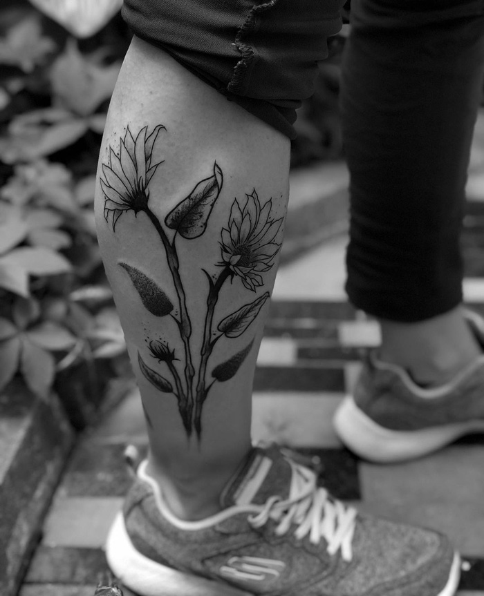 Black and white calf tattoo featuring floral design, showcasing unique calf tattoo ideas.
