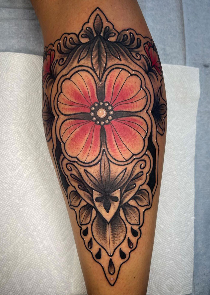 Intricate floral calf tattoo design with vibrant colors and bold outlines.