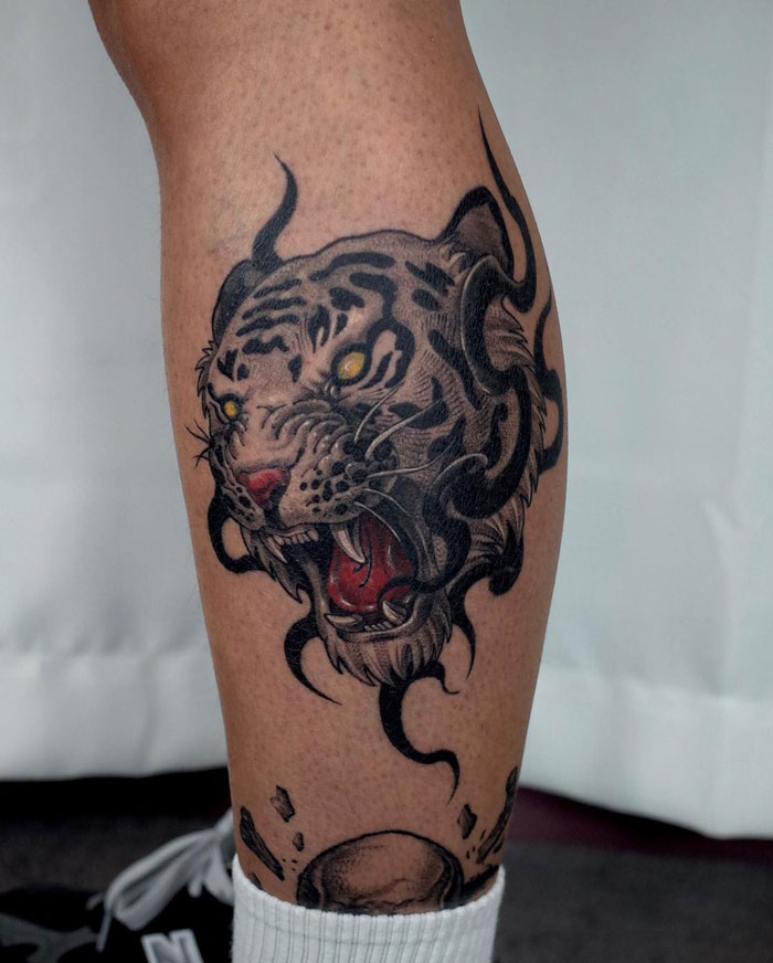 Tiger design calf tattoo showcasing unique artistic details.