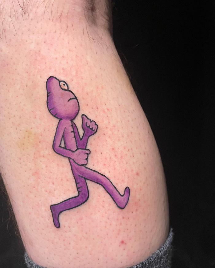 Purple cartoon figure tattoo on calf displaying a unique design.