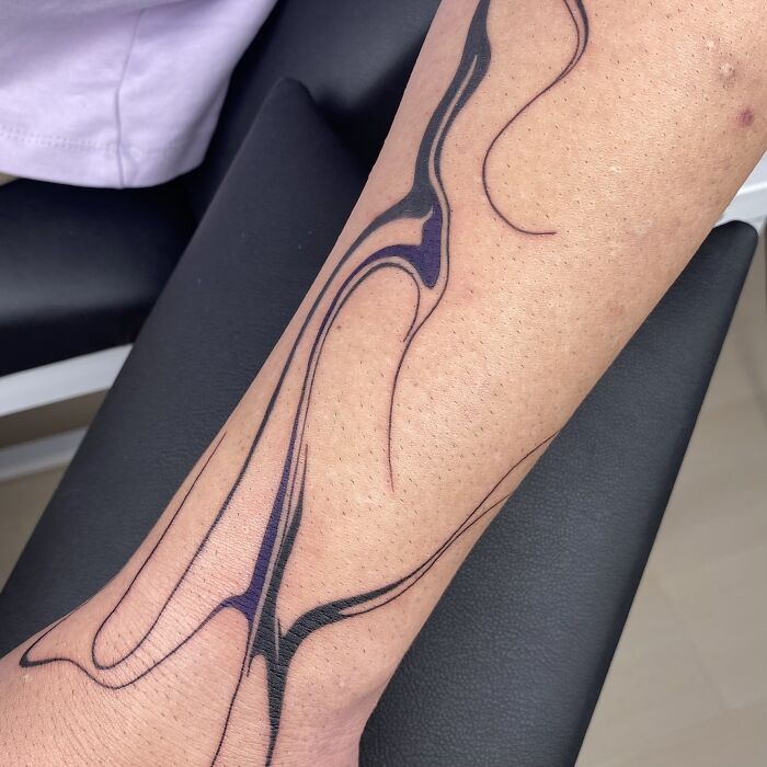 Flowing tattoo design on forearm inspired by traditional marbling techniques.