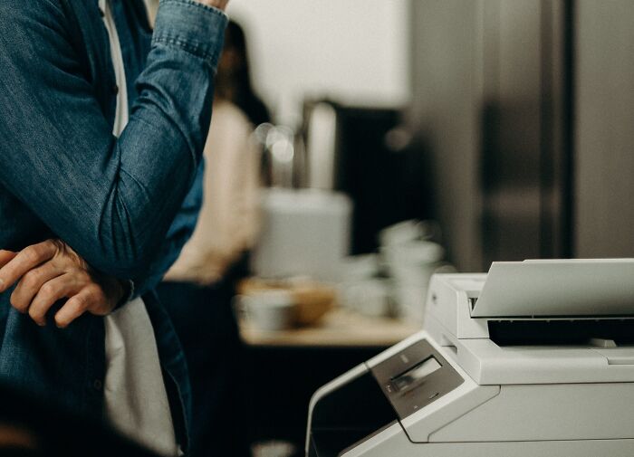 Man Waiting For Printer To Finnish Printing 