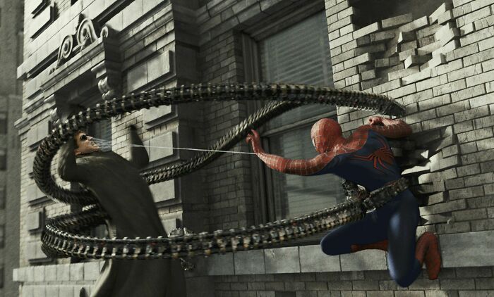 En Spider-Man 2 (2002), el Dr. Otto Octavius era un hombre corriente que tenía cuatro brazos mecánicos fusionados en su columna vertebral. Al parecer, esto explica cómo puede encogerse de hombros ante múltiples puñetazos en la cara de un tipo que puede parar un tren con sus propias manos