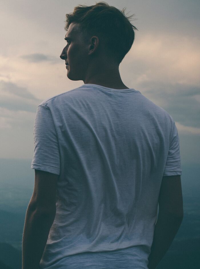 Man wearing white shirt standing and looking