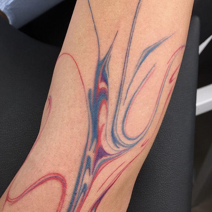 Flowing tattoo design inspired by traditional marbling art on forearm.