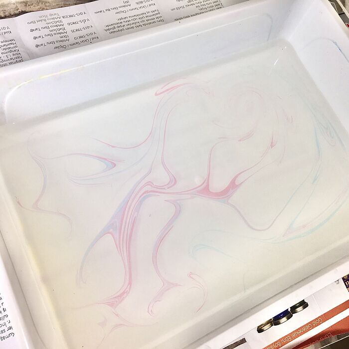 Marbling design with pink and blue swirls in a white tray, illustrating the Sernakkab technique.