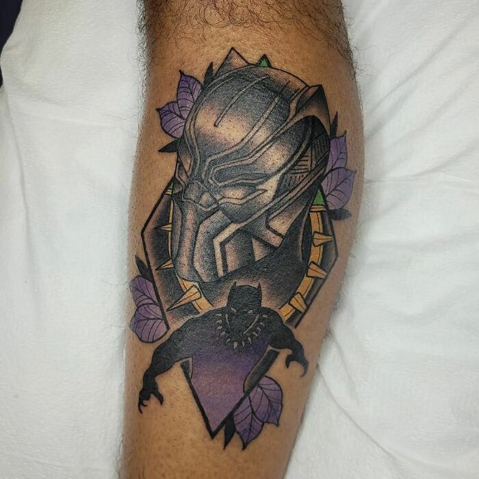 Marvel tattoo featuring Black Panther design with purple accents on calf.