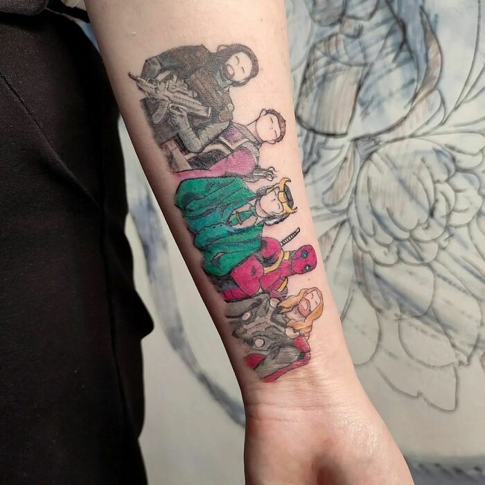 Marvel tattoos featuring superhero characters on a forearm, showcasing colorful designs.