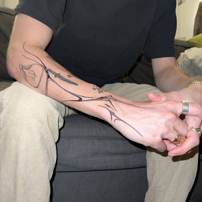 Tattoo design inspired by traditional marbling on a person's forearm, showcasing intricate and flowing patterns.