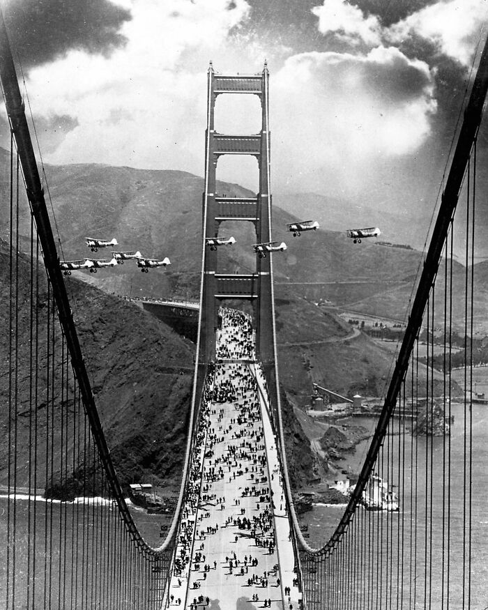 Planes Fly Between The Towers And Pedestrians Cross As Part Of The Celebration Of The Opening Of The Golden Gate Bridge In May Of 1937