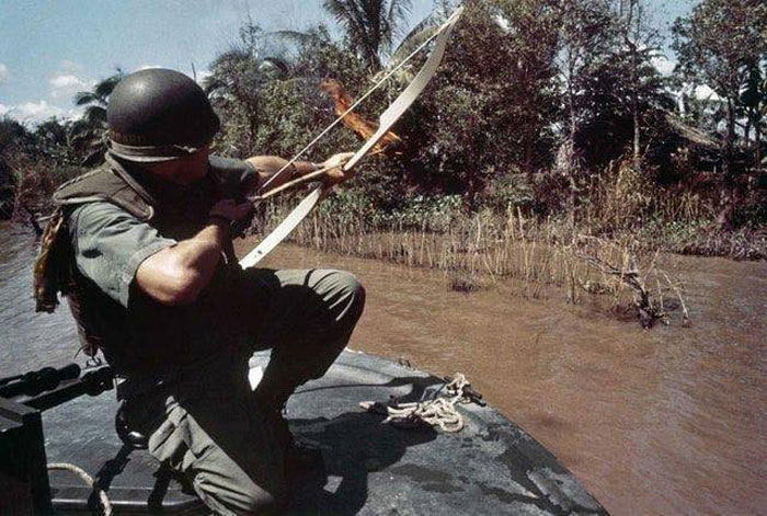 Lieutenant Commander Donald D. Sheppard, Of Coronado, California, Aims A Flaming Arrow At A Bamboo Hut Concealing A Fortified Viet Cong Bunker On The Banks Of The Bassac River, Vietnam, On December 8, 1967