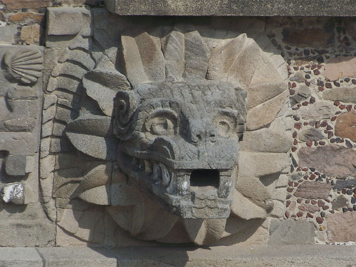 Rock statue of Feathered Serpent head on a wall 