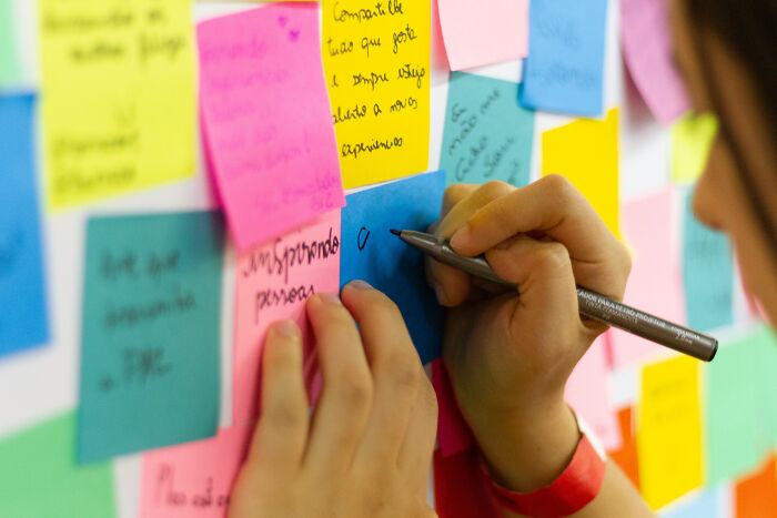 Person Writing Messages On Sticky Notes 