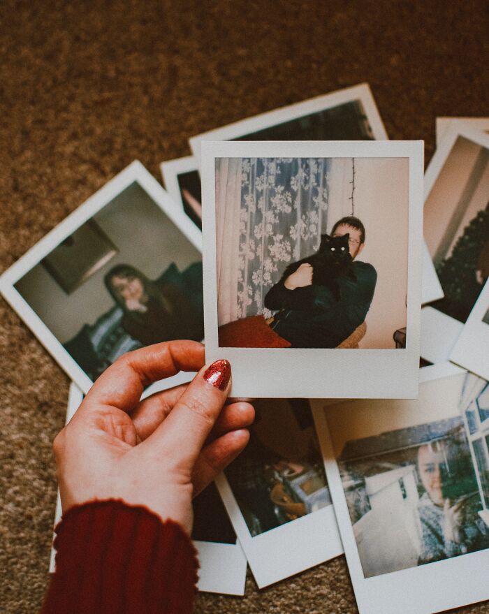 Woman Holding A Lot Of Polaroid Pictures 