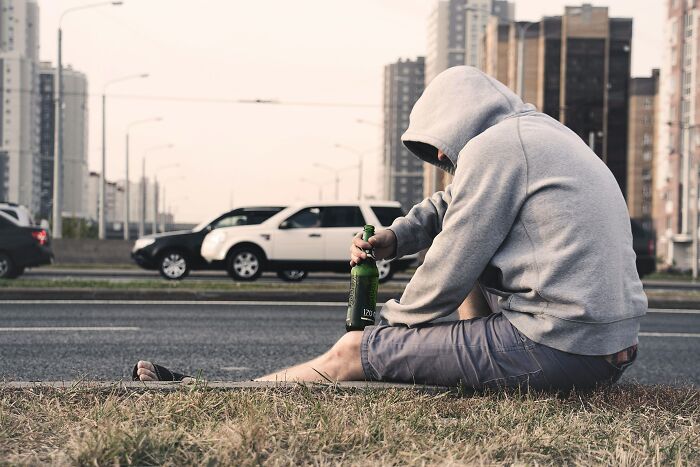 Sad Person Drinking Near The Road 