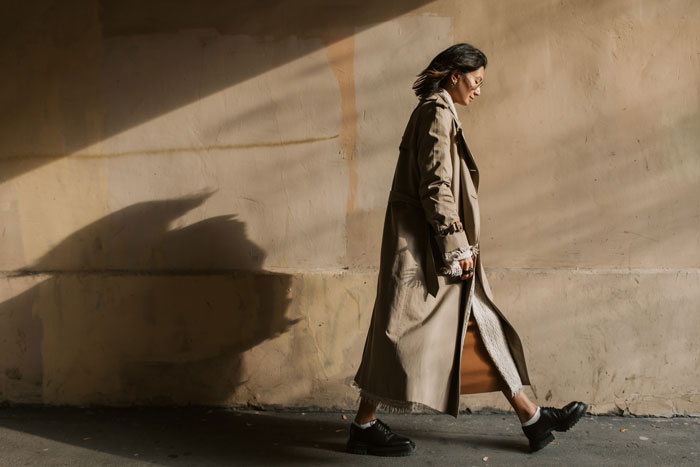 Woman walking wearing gray coat