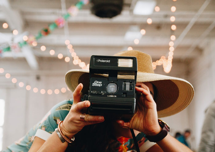 Woman taking a picture with polaroid camera