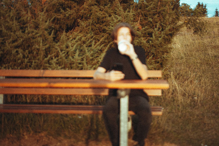Blurred person sitting at the table and drinking