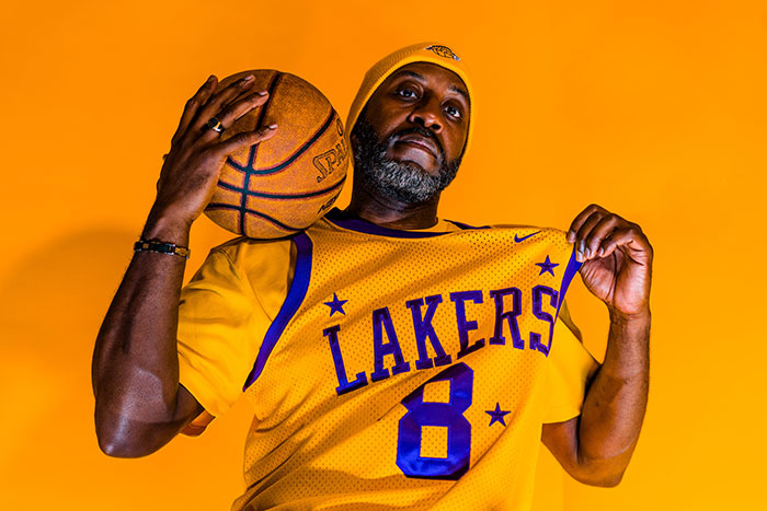 Picture of man wearing yellow basketball clothes and holding ball