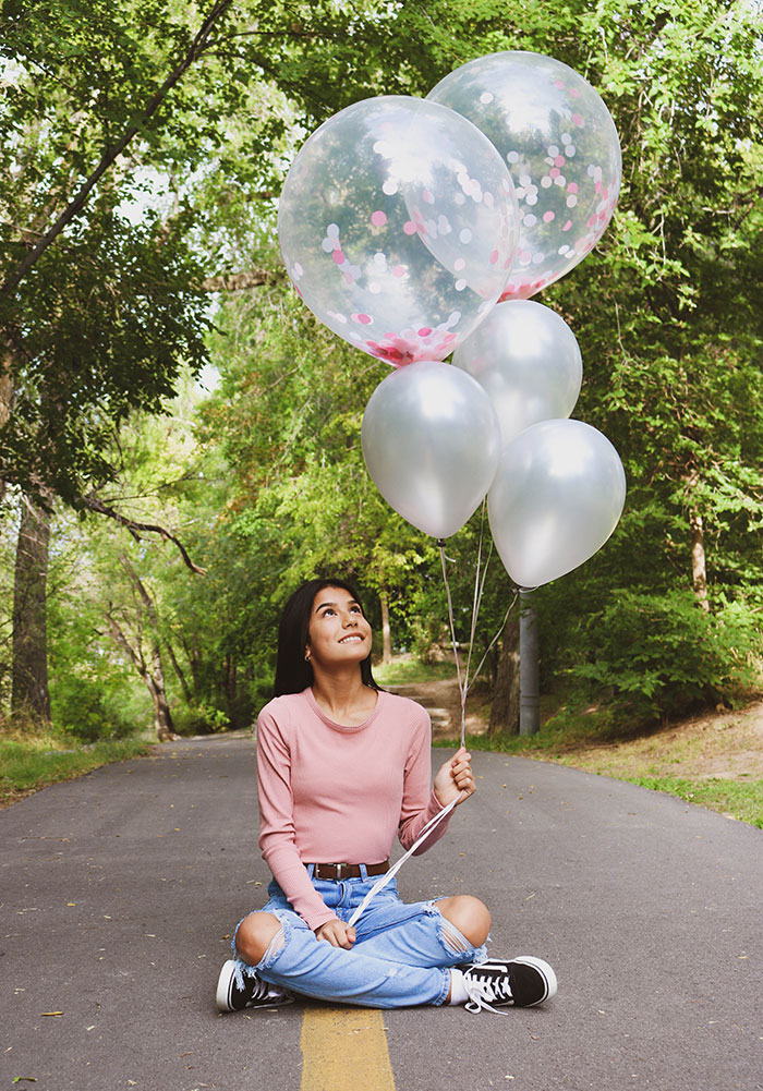 Picture of woman sitting on the road and holding balloons