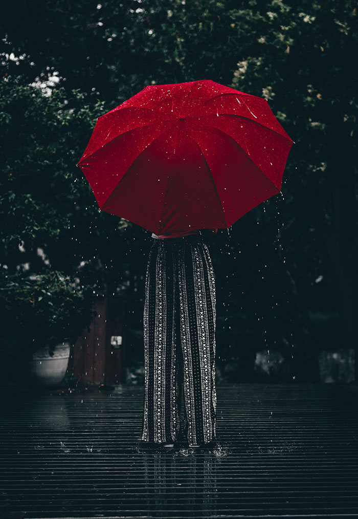 Picture of person holding red umbrella in the rain