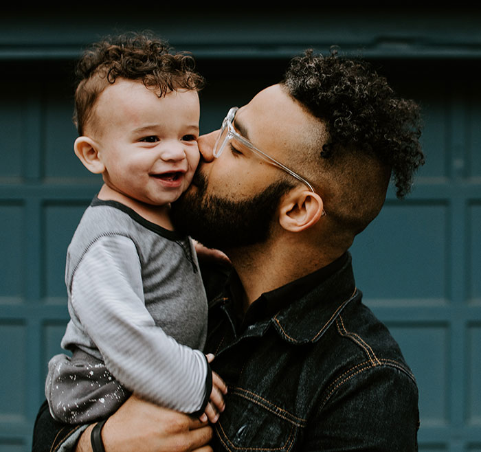 Picture of man holding and kissing a baby