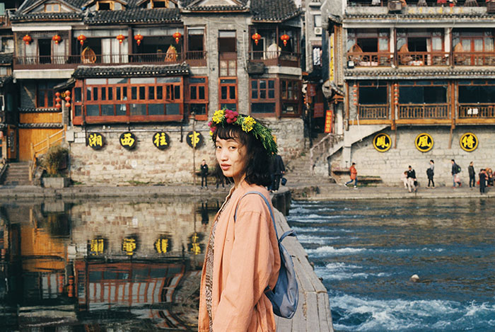 Picture of woman near old buildings and river