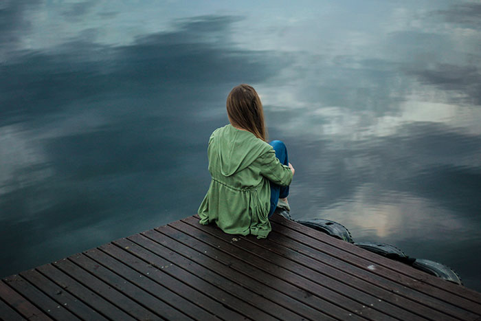 Person sitting near lake
