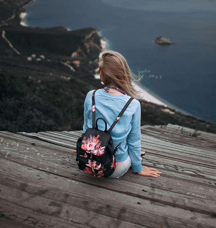 Woman sitting and looking at ocean