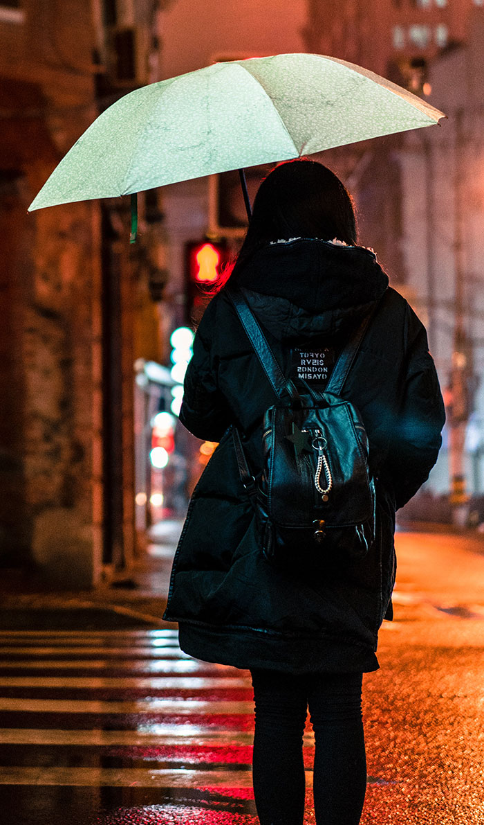 Woman walking and holding umbrella