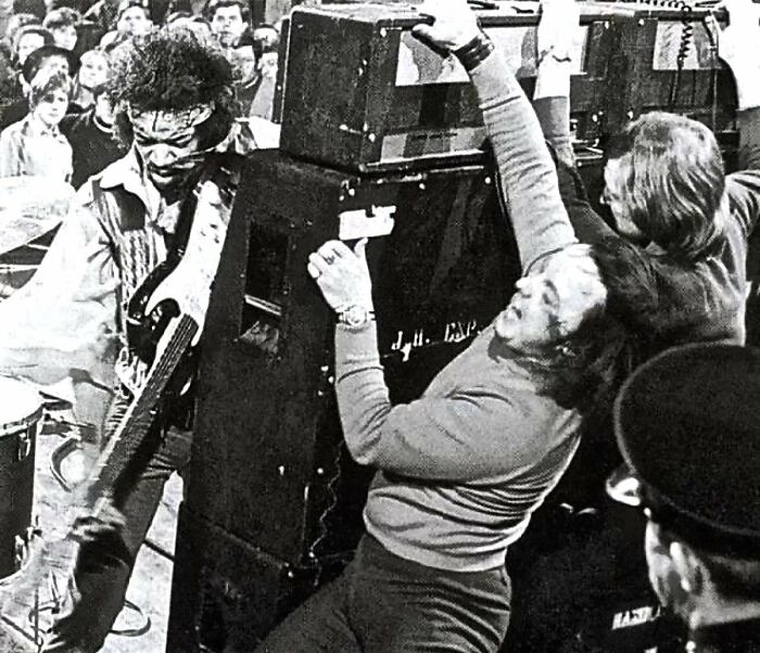 Jimi Hendrix In Action. Great Photo Of The Roadie Having To Hold Up The Amp Stack