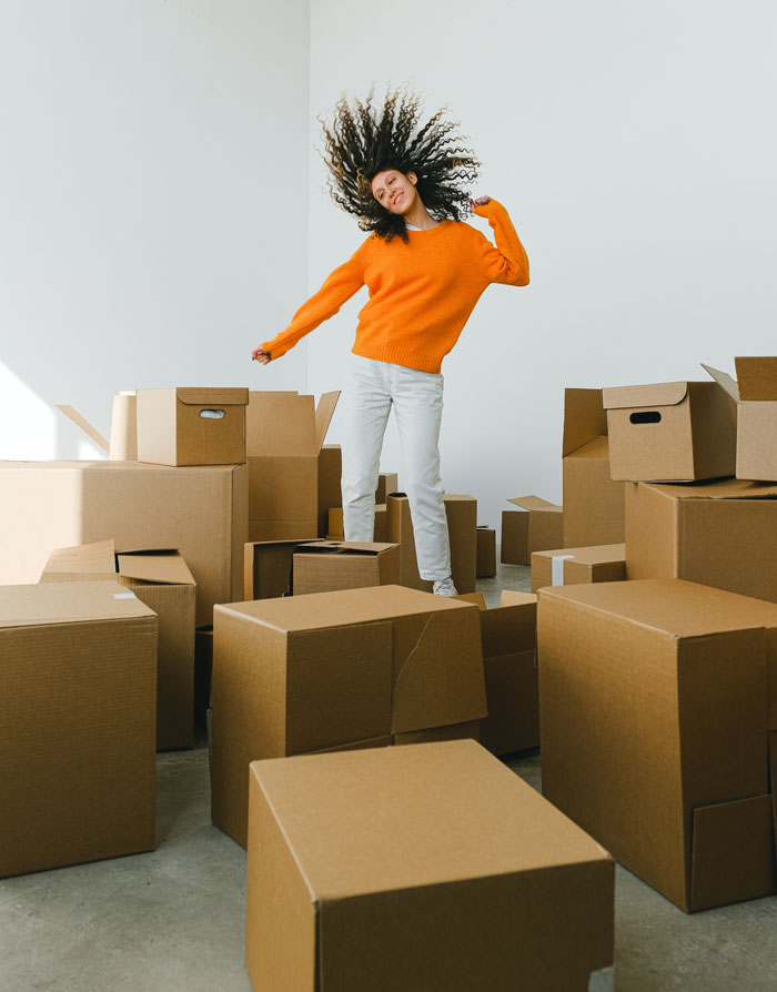 Woman dancing around carton boxes 