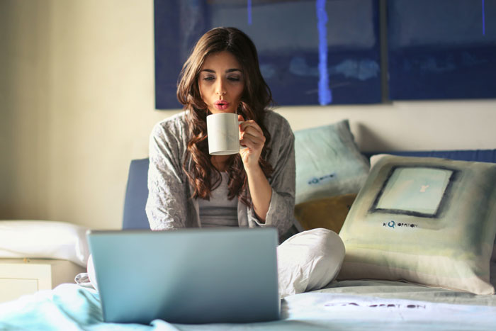 Woman sitting on the bed drinking coffee 