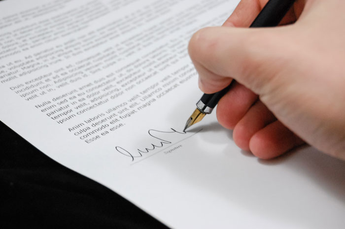 Person signs a document