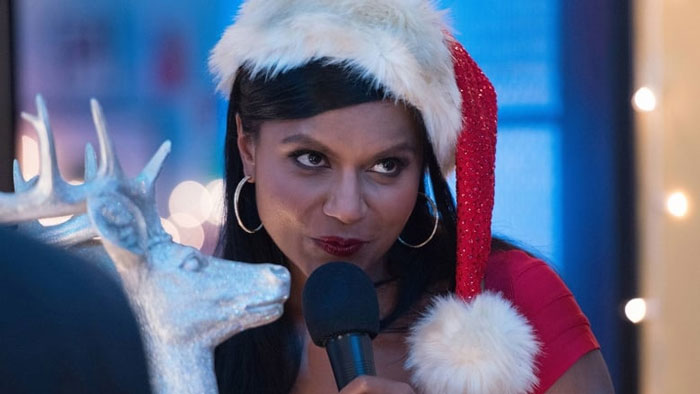 Mindy wearing Santa’s cap and singing 