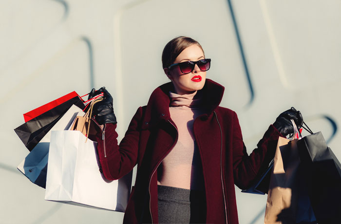 Woman wearing sunglasses holding shopping bags 
