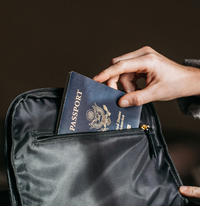 Person putting a passport in a bag