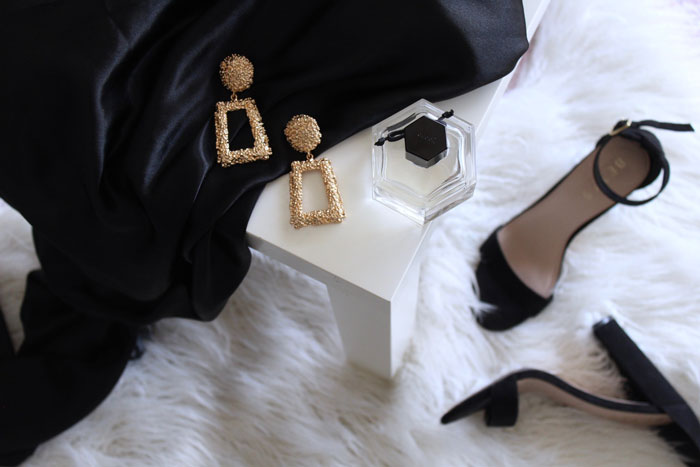 A pair of golden earrings, perfume and a pair of a black heels 