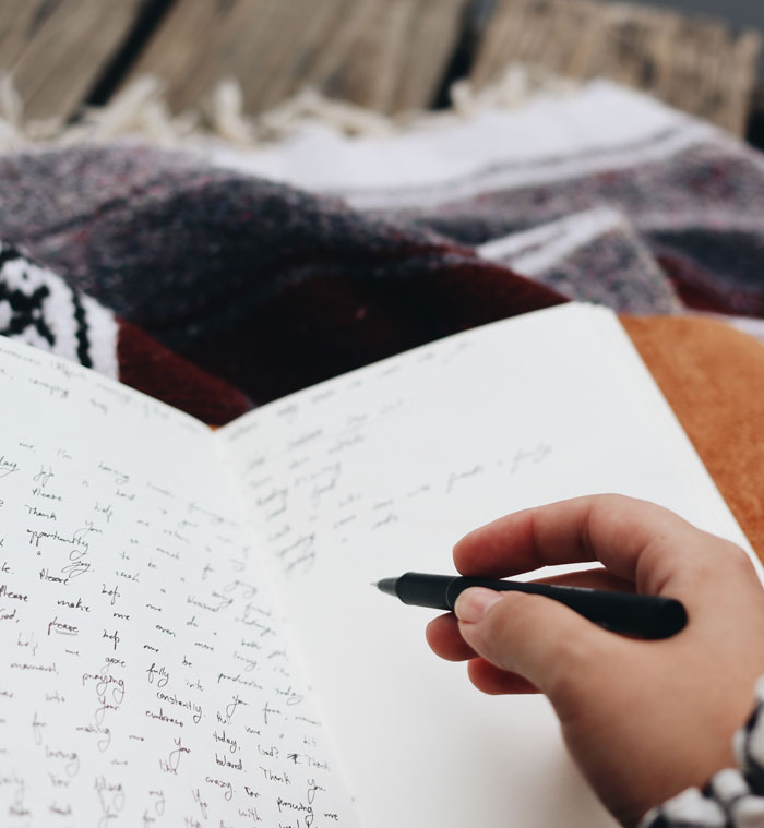 A person writing something in the journal 