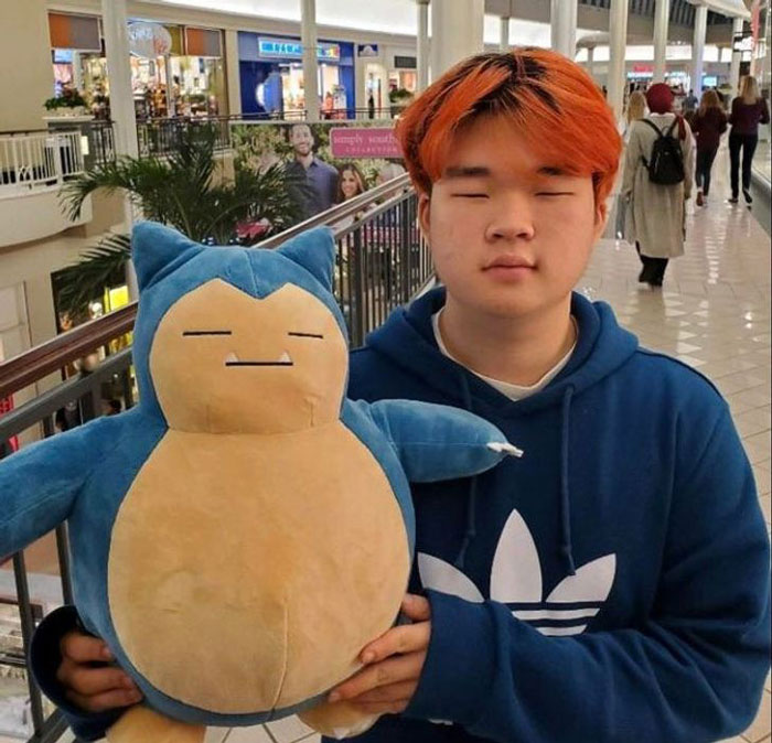 Ginger boy holding a plush toy of Snorlax From Pokémon