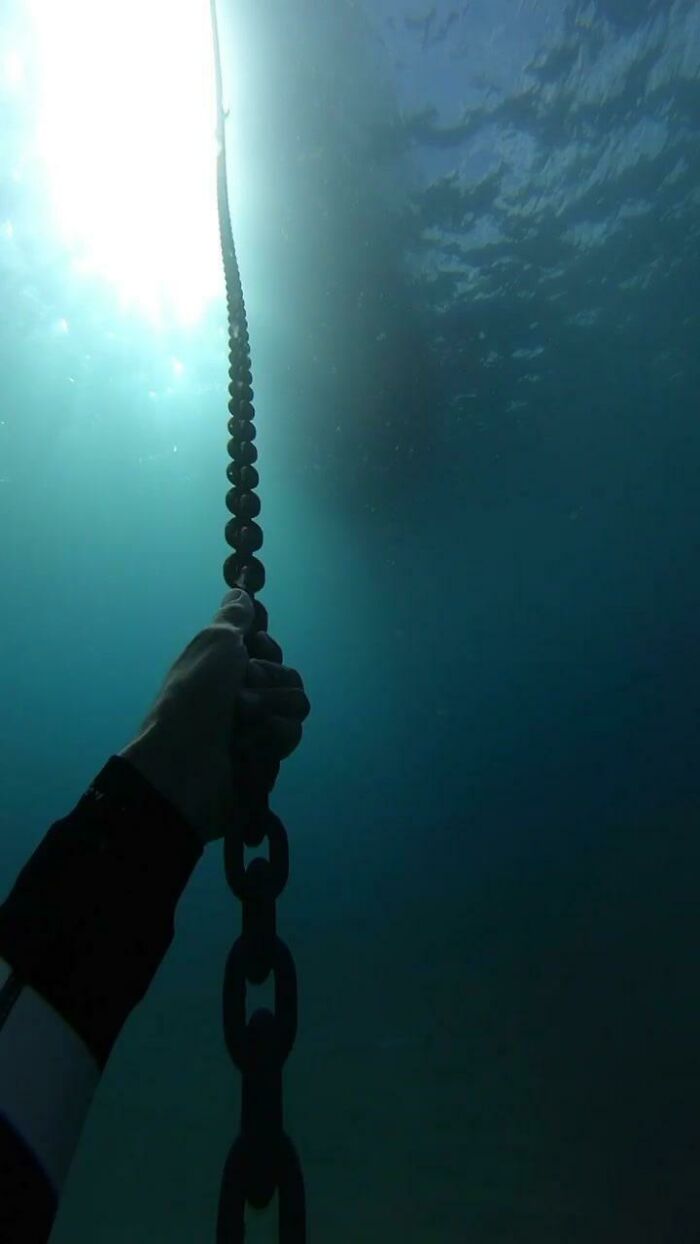 Freediving In Hawaii Whilst Tugging On A Chain Of A Buoy Underwater