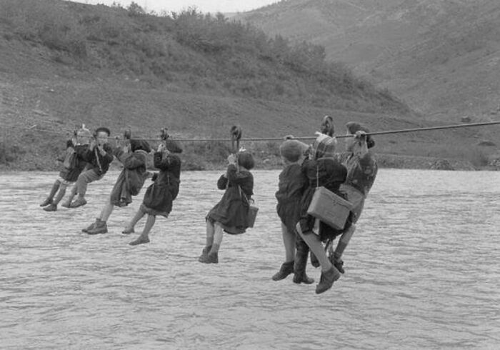 Los niños cruzan el río utilizando poleas de camino a la escuela, 1959, Italia